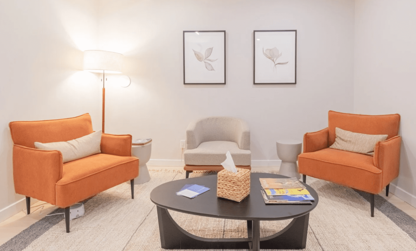 cozy brooklyn heights therapy office with orange sofa and chairs and warm lighting